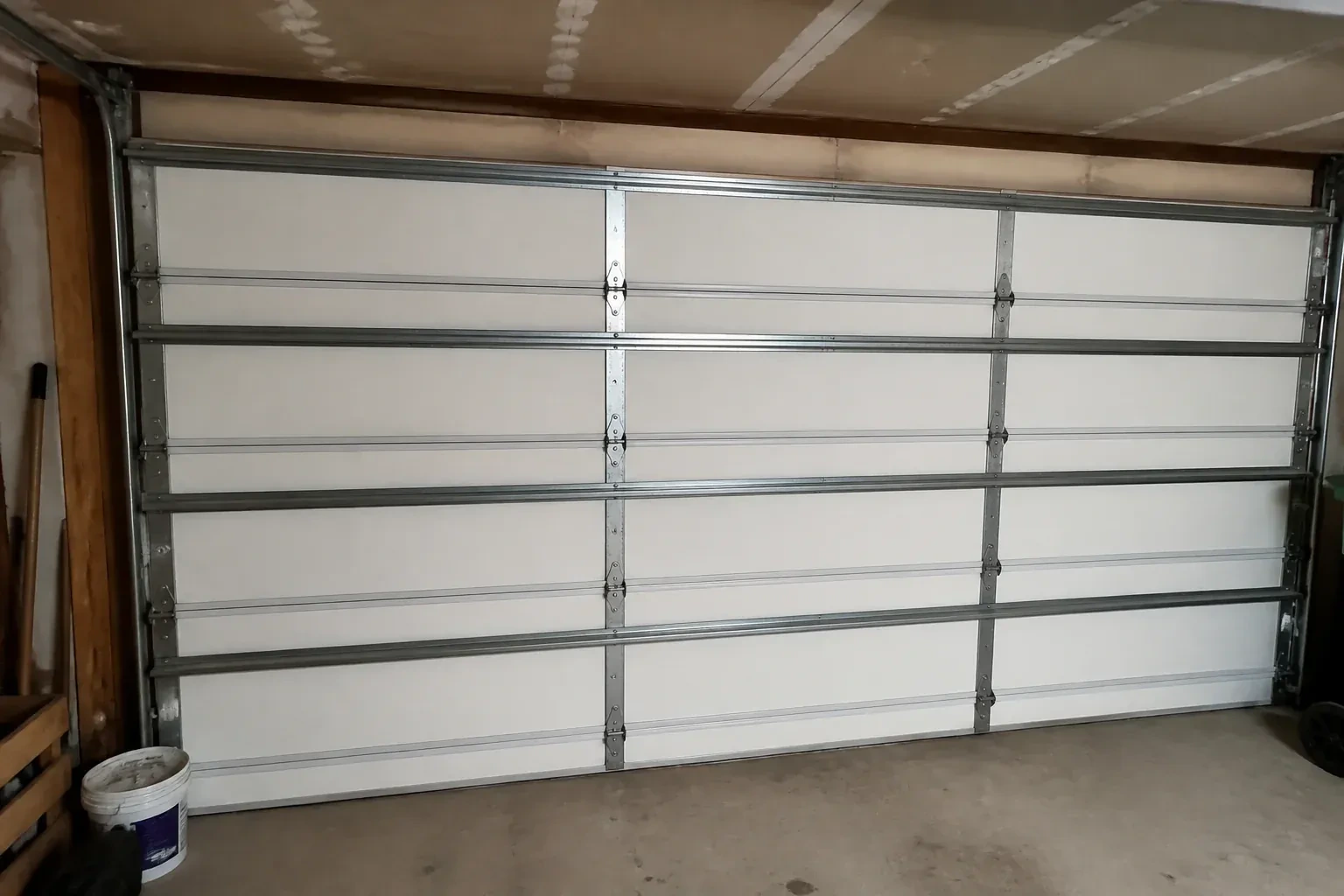 Interior of a closed sectional door with horizontal metal reinforcement struts. — Wind-Rated Garage Door Replacement, Woolwich